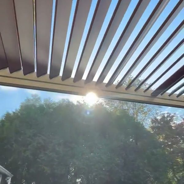 Bronze louvered pergola over a fire-pit patio