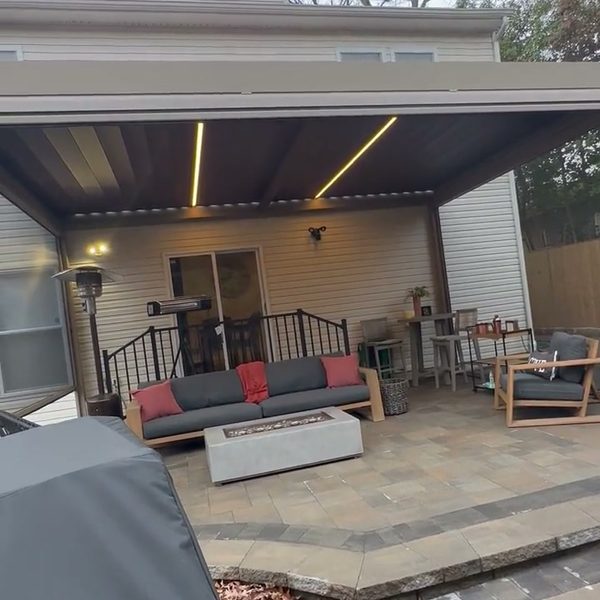 Louvered pergola with LED lights over a paver patio
